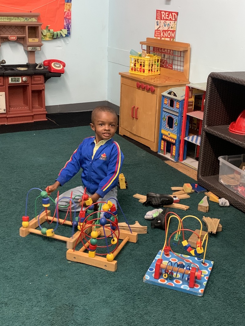 A toddler boy is playing learning games.