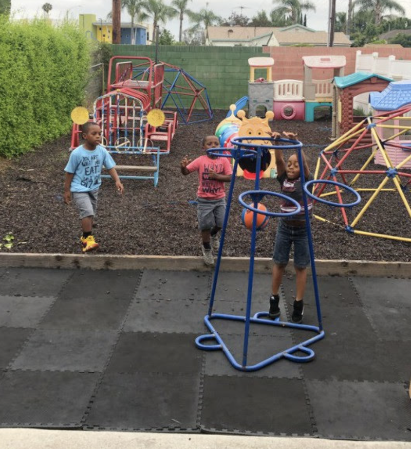 Kids are shooting the basketball in the hoop on The Learning Box playground.